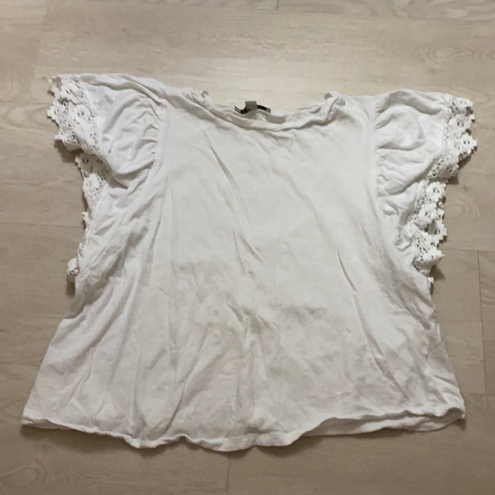 White t-shirt with detailed sleeves.